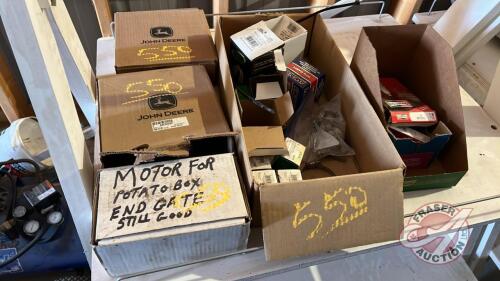 Pallet w/ (2) boxes of JD corn header parts, elec motor for potato box end gate, Champion spark plugs, box of hose clamps